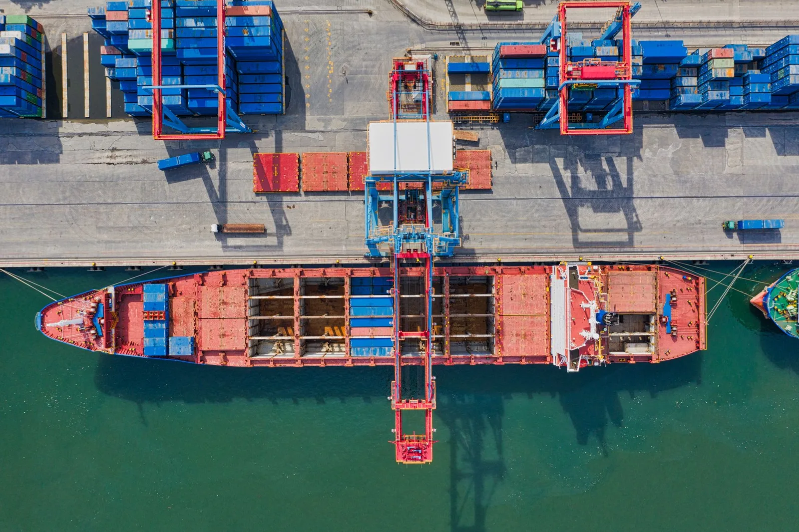 Navio de carga e contentores num terminal portuário
